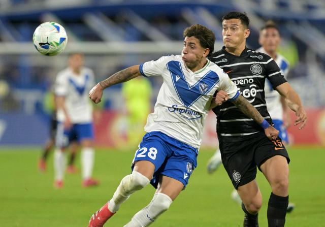 Velez Sarsfield's forward #28 Maher Carrizo and Olimpia's defender #15 Axel Alfonzo fight for the ball during the Copa Libertadores group stage first round football match between Argentina's Velez Sarsfield and Paraguay's Olimpia at the Jose Amalfitani stadium in Buenos Aires on May 8, 2025. (Photo by JUAN MABROMATA / AFP)