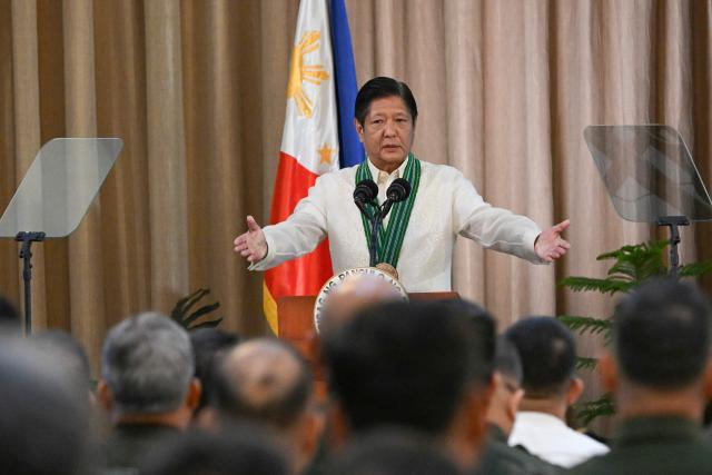 (FILES) Philippines' President Ferdinand Marcos Jr. gestures to army officers as he delivers a speech during the 128th founding anniversary of the Philippine army at its headquarters in Manila on March 22, 2025. (Photo by Ted ALJIBE / AFP)