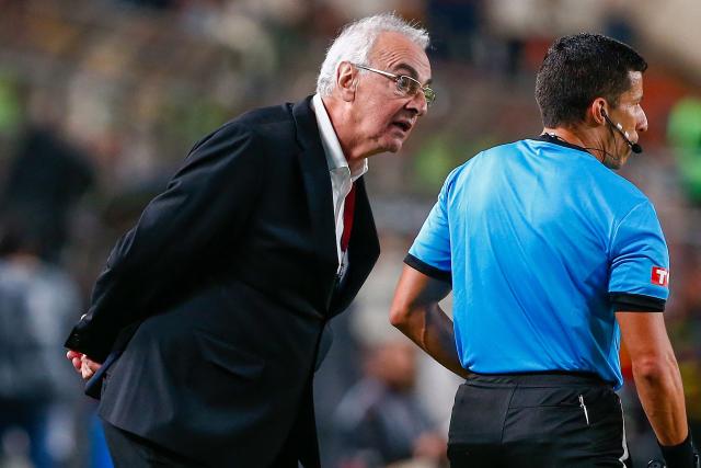 Universitario's Uruguayan head coach Jorge Fossati gestures next to a referee during the Copa Libertadores group stage first round football match between Peru's Universitario de Lima and Ecuador's Independiente del Valle at the Monumental "U" Marathon stadium in Lima, on May 8, 2025. (Photo by STRINGER / AFP)