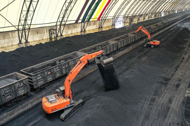 Excavators unload coal from rail cars into a coal storage facility of a logistics company in Binzhou, in eastern China's Shandong province on May 9, 2025. (Photo by AFP) / China OUT