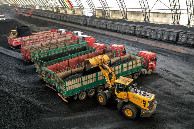 Wheel loaders load coal onto trucks at a coal storage facility of a logistics company in Binzhou, in eastern China's Shandong province on May 9, 2025. (Photo by AFP) / China OUT