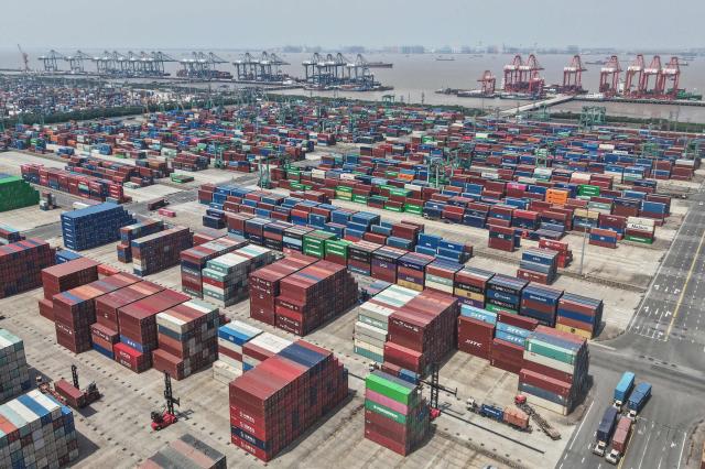 Shipping containers are stacked at a port in Shanghai on May 9, 2025. China said on May 9 sales to the United States slumped last month while its total exports topped forecasts, as Beijing fought a gruelling trade war with its superpower rival. (Photo by AFP) / China OUT