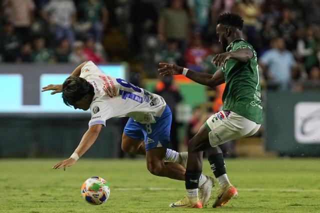 Cruz Azul's forward #18 Luka Romero and Leon's Colombian forward #11 Stiven Mendoza fight for the ball during the Liga MX Clausura tournament quarter-final first leg football match between Leon and Cruz Azul, at the Leon (Nou Camp) stadium in Leon, state of Guanajuato, Mexico on May 8, 2025. (Photo by Mario ARMAS / AFP)