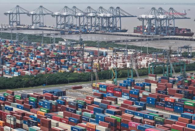 Shipping containers are stacked at a port in Shanghai on May 9, 2025. China said on May 9 sales to the United States slumped last month while its total exports topped forecasts, as Beijing fought a gruelling trade war with its superpower rival. (Photo by AFP) / China OUT