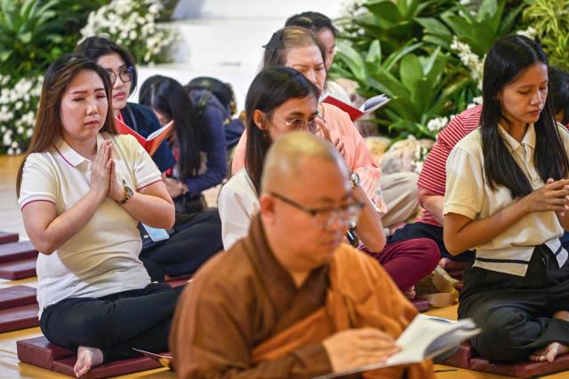 Devotees pray next to a statue of Buddha at a shopping mall in Surabaya on May 9, 2025, ahead of 'Vesak' festival, also known as Buddha Jayanti to commemorate the birth, enlightenment and death of Buddha. (Photo by Juni KRISWANTO / AFP)