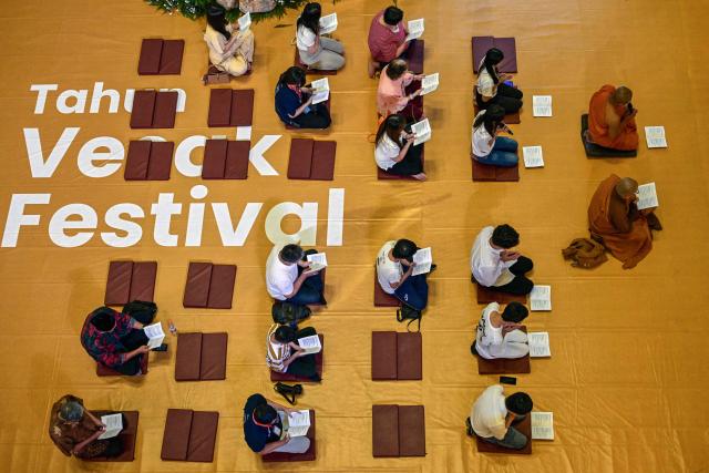 Devotees pray next to a statue of Buddha at a shopping mall in Surabaya on May 9, 2025, ahead of 'Vesak' festival, also known as Buddha Jayanti to commemorate the birth, enlightenment and death of Buddha. (Photo by Juni KRISWANTO / AFP)
