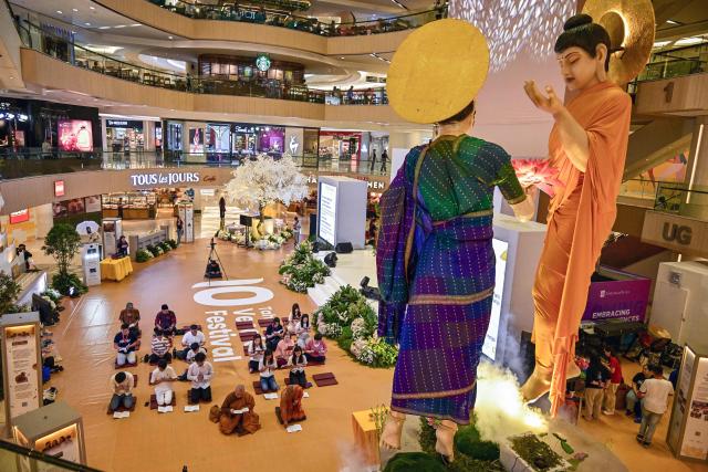 Devotees pray next to a statue of Buddha at a shopping mall in Surabaya on May 9, 2025, ahead of 'Vesak' festival, also known as Buddha Jayanti to commemorate the birth, enlightenment and death of Buddha. (Photo by Juni KRISWANTO / AFP)