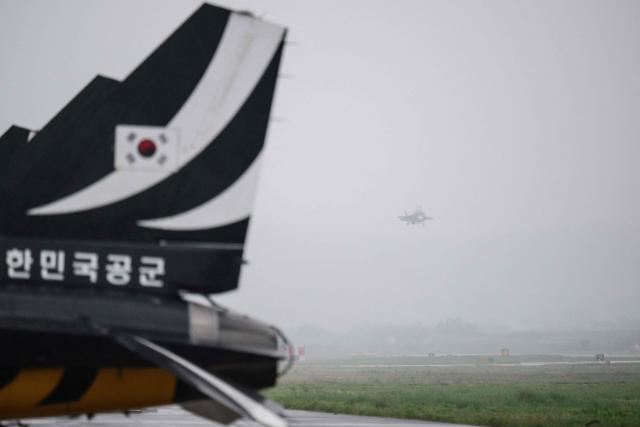 A US F-35B (R) lands beyond Republic of Korea Air Force (ROKAF) 'Black Eagle' aerobatics planes during a media day demonstration for the Osan Air Power Days 2025 at Osan Air Base in Pyeongtaek on May 9, 2025. (Photo by ANTHONY WALLACE / AFP)