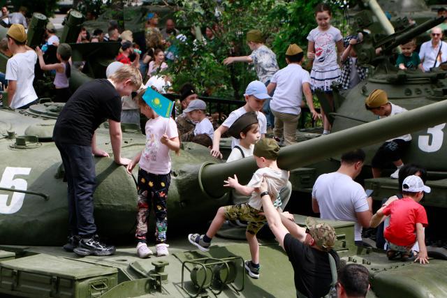 Children play on Soviet-era tanks during a ceremony marking the 80th anniversary of the Soviet Union's victory over Nazi Germany in World War Two (WWII) in Almaty on May 9, 2025. (Photo by Ruslan PRYANIKOV / AFP)