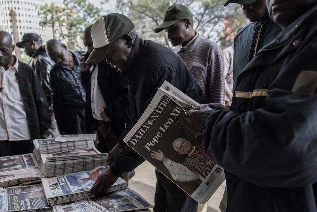 Residents gather at a street-side newspaper stall to read look at newspapers with the front pages bearing headlines and images announcing the newly elected Pope Leo XIV, Robert Prevost, in downtown Nairobi, on May 9, 2025. Robert Francis Prevost was on May 8, 2025 elected the first pope from the United States, the Vatican announced. A moderate who was close to Pope Francis and spent years as a missionary in Peru, he becomes the Catholic Church's 267th pontiff, taking the papal name Leo XIV. (Photo by SIMON MAINA / AFP)