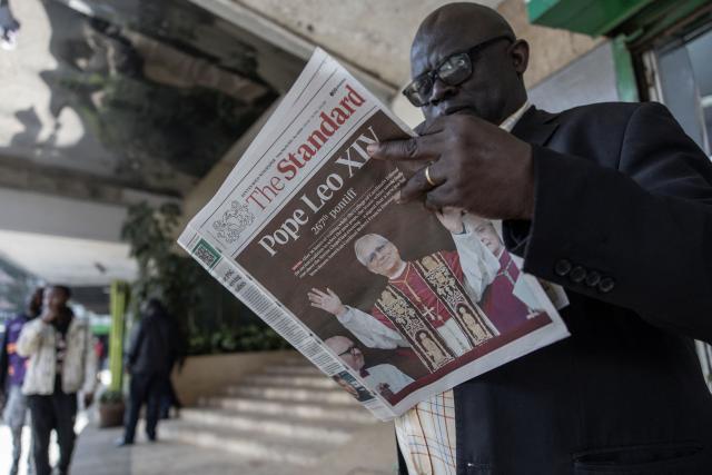 A resident stands at a street-side newspaper stall to read The Standard newspaper with the front page bearing headlines and images announcing the newly elected Pope Leo XIV, Robert Prevost, in downtown Nairobi, on May 9, 2025. Robert Francis Prevost was on May 8, 2025 elected the first pope from the United States, the Vatican announced. A moderate who was close to Pope Francis and spent years as a missionary in Peru, he becomes the Catholic Church's 267th pontiff, taking the papal name Leo XIV. (Photo by SIMON MAINA / AFP)