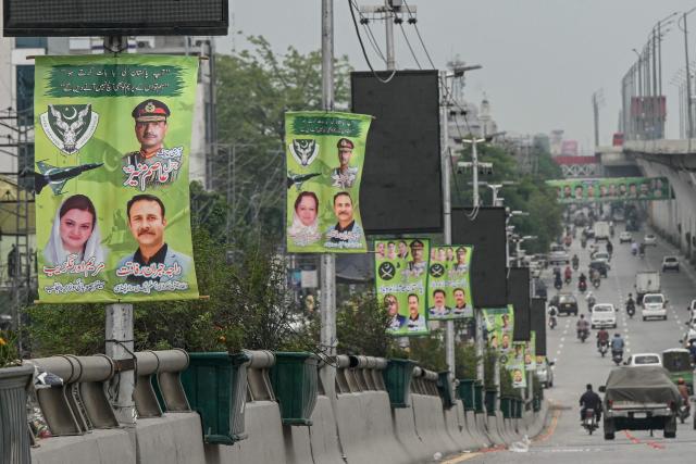 Commuters move past posters, installed on the roadside, featuring country's Chief of Army Staff General Syed Asim Munir (top, right) in Rawalpindi on May 9, 2025. India and Pakistan accused each other on May 8 of carrying out waves of drone attacks, as deadly confrontations between the nuclear-armed foes drew global calls for calm. (Photo by Farooq NAEEM / AFP)