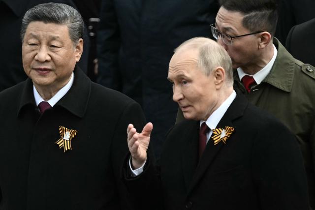 Russian President Vladimir Putin and Chinese President Xi Jinping attend a ceremony to lay flowers at the Tomb of the Unknown Soldier by the Kremlin wall in central Moscow on May 9, 2025. Russia celebrates the 80th anniversary of the Soviet Union's victory over Nazi Germany in World War Two (WWII). (Photo by Angelos Tzortzinis / AFP)