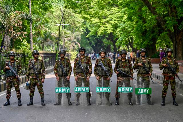 Bangladesh Army soldiers stand guard as protesters gather in front of the State Guest House Jamuna, the official residence of Bangladesh's Chief Advisor Office of Interim Government Muhammad Yunus, demanding a ban on the ousted Sheikh Hasina’s party, the Awami League, in Dhaka on May 9, 2025. (Photo by Munir UZ ZAMAN / AFP)