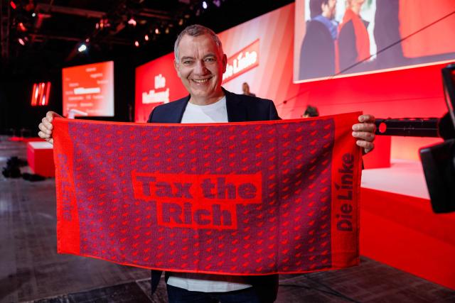 Jan van Aken, co-leader of Germany's The Left (Die Linke) party is pictured with "Tax the Rich" merchandise prior to the start of the federal party congress in Chemnitz, eastern Germany on May 9, 2025. (Photo by JENS SCHLUETER / AFP)