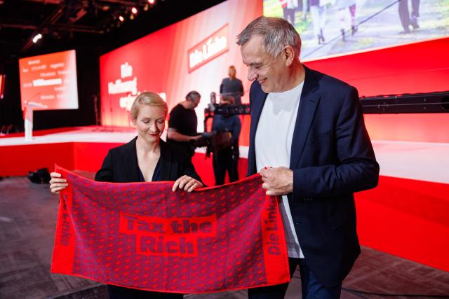 Ines Schwerdtner, co-leader of Germany's The Left (Die Linke) party, and Jan van Aken, co-leader of Germany's The Left (Die Linke) party are pictured with "Tax the Rich" merchandise prior to the start of the federal party congress in Chemnitz, eastern Germany on May 9, 2025. (Photo by JENS SCHLUETER / AFP)