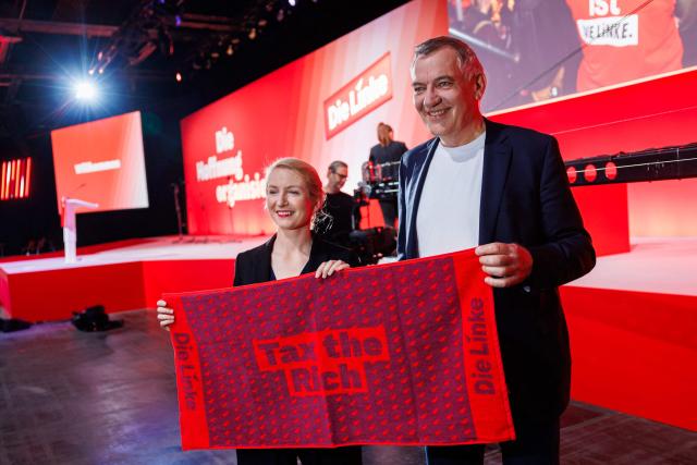 Ines Schwerdtner, co-leader of Germany's The Left (Die Linke) party, and Jan van Aken, co-leader of Germany's The Left (Die Linke) party are pictured with "Tax the Rich" merchandise prior to the start of the federal party congress in Chemnitz, eastern Germany on May 9, 2025. (Photo by JENS SCHLUETER / AFP)