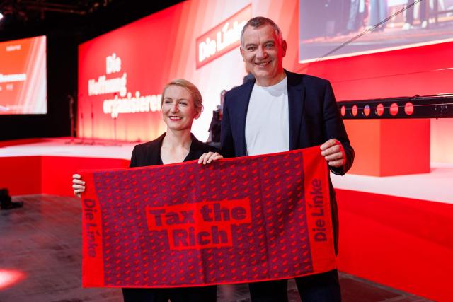 Ines Schwerdtner, co-leader of Germany's The Left (Die Linke) party, and Jan van Aken, co-leader of Germany's The Left (Die Linke) party are pictured with "Tax the Rich" merchandise prior to the start of the federal party congress in Chemnitz, eastern Germany on May 9, 2025. (Photo by JENS SCHLUETER / AFP)