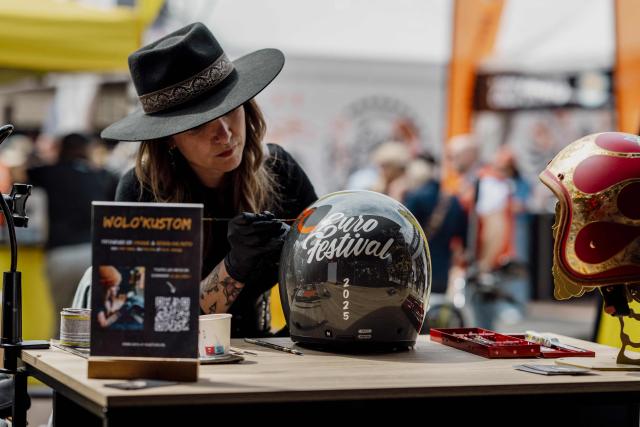 An artist paints on a customised motorbike helmet during the Harley-Davidson Euro 2025 Festival near Grimaud, southern France, on May 9, 2025. (Photo by Frederic DIDES / AFP)