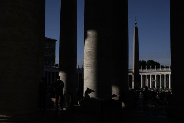 A carabineri officer stand guard as he patrols under the colonnade at St Peter's Square with the obelisk in the background in the Vatican on May 9, 2025. (Photo by JEFF PACHOUD / AFP)