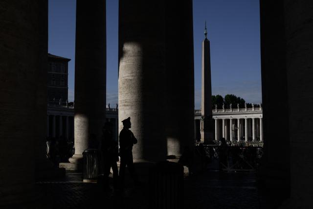This photograph shows the shadow of a carabineri officer standing guard as he patrols under the colonnade at St Peter's Square with the obelisk in the background in the Vatican on May 9, 2025. (Photo by JEFF PACHOUD / AFP)