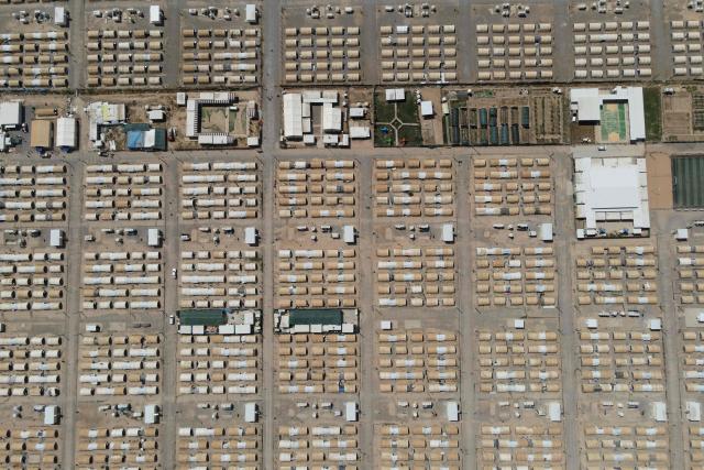 This aerial picture shows tents lined up in the Al-Amal Camp (formerly Al-Jadaa), south of Mosul in northern Iraq, which houses Iraqi families who have been repatriated from Syria's Al-Hol camp, on May 8, 2025. Upon arrival in Iraq, authorities usually keep returnees from Al-Hol, home to tens of thousands of people including family members of suspected jihadists, for weeks or even months at what officials describe as a "psychological rehabilitation" in Al-Jadaa, where they also undergo security checks. (Photo by Zaid AL-OBEIDI / AFP)