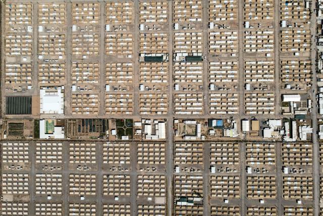 This aerial picture shows tents lined up in the Al-Amal Camp (formerly Al-Jadaa), south of Mosul in northern Iraq, which houses Iraqi families who have been repatriated from Syria's Al-Hol camp, on May 8, 2025. Upon arrival in Iraq, authorities usually keep returnees from Al-Hol, home to tens of thousands of people including family members of suspected jihadists, for weeks or even months at what officials describe as a "psychological rehabilitation" in Al-Jadaa, where they also undergo security checks. (Photo by Zaid AL-OBEIDI / AFP)
