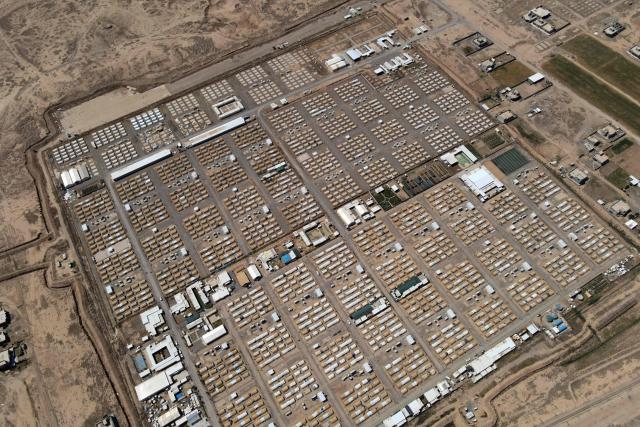 This aerial picture shows tents lined up in the Al-Amal Camp (formerly Al-Jadaa), south of Mosul in northern Iraq, which houses Iraqi families who have been repatriated from Syria's Al-Hol camp, on May 8, 2025. Upon arrival in Iraq, authorities usually keep returnees from Al-Hol, home to tens of thousands of people including family members of suspected jihadists, for weeks or even months at what officials describe as a "psychological rehabilitation" in Al-Jadaa, where they also undergo security checks. (Photo by Zaid AL-OBEIDI / AFP)