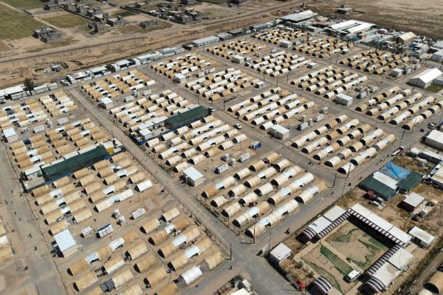 This aerial picture shows tents lined up in the Al-Amal Camp (formerly Al-Jadaa), south of Mosul in northern Iraq, which houses Iraqi families who have been repatriated from Syria's Al-Hol camp, on May 8, 2025. Upon arrival in Iraq, authorities usually keep returnees from Al-Hol, home to tens of thousands of people including family members of suspected jihadists, for weeks or even months at what officials describe as a "psychological rehabilitation" in Al-Jadaa, where they also undergo security checks. (Photo by Zaid AL-OBEIDI / AFP)