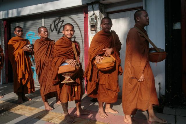Buddhist monks walk in a line to receive alms from devotees along a street in Magelang, Central Java, on May 10, 2025, ahead of Waisak, or Vesak Day. Vesak is the most sacred day for Buddhists, commemorating the birth, enlightenment and death of Siddhartha Gautama, the Buddha, all traditionally believed to have occurred on the full moon day of the Vesakha month in the ancient Indian lunar calendar. (Photo by DEVI RAHMAN / AFP)