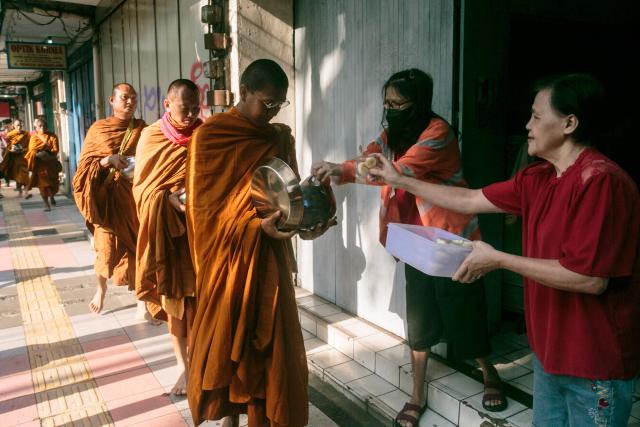 Buddhist monks walk in a line to receive alms along a street in Magelang, Central Java, on May 10, 2025, ahead of Waisak, or Vesak Day. Vesak is the most sacred day for Buddhists, commemorating the birth, enlightenment and death of Siddhartha Gautama, the Buddha, all traditionally believed to have occurred on the full moon day of the Vesakha month in the ancient Indian lunar calendar. (Photo by DEVI RAHMAN / AFP)