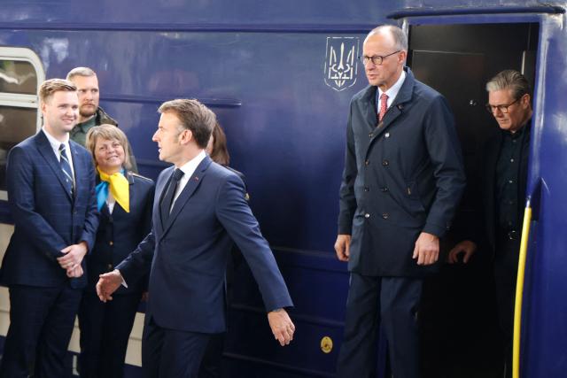 France's President Emmanuel Macron (L), Germany's Chancellor Friedrich Merz (C) and Britain's Prime Minister Keir Starmer (R) step down from a train as they arrive at Kyiv railway station on May 10, 2025, ahead of a gathering of European leaders in the Ukranian capital. The leaders of Britain, France, Germany and Poland make an unprecedented joint visit to Kyiv on May 10, 2025 for talks with Ukraine's President Volodymyr and to urge Russia to agree a ceasefire, a joint statement said. (Photo by Ludovic MARIN / POOL / AFP)