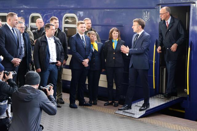 France's President Emmanuel Macron and Germany's Chancellor Friedrich Merz (R) step down from a train as they arrive at Kyiv railway station on May 10, 2025, ahead of a gathering of European leaders in the Ukranian capital. The leaders of Britain, France, Germany and Poland make an unprecedented joint visit to Kyiv on May 10, 2025 for talks with Ukraine's President Volodymyr and to urge Russia to agree a ceasefire, a joint statement said. (Photo by Ludovic MARIN / POOL / AFP)