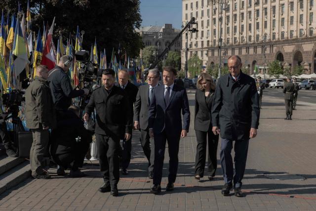 (From L) Ukraine's President Volodymyr Zelensky, Poland's Prime Minister Donald Tusk, Britain's Prime Minister Keir Starmer, France's President Emmanuel Macron, Olena Zelenska and Germany's Chancellor Friedrich Merz pay their respects to the victims of war at the  Memorial for the Fallen at the Independence Square (Maidan) in Kyiv on May 10, 2025, ahead of a gathering of European leaders in the Ukranian capital. The leaders of Britain, France, Germany and Poland make an unprecedented joint visit to Kyiv on May 10, 2025 for talks with Ukraine's President Volodymyr and to urge Russia to agree a ceasefire, a joint statement said. (Photo by Roman PILIPEY / AFP)