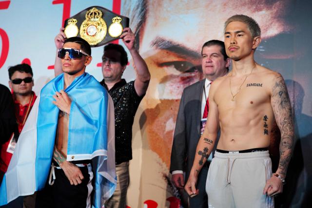 Fernando Martinez of Argentina (front L) and Kazuto Ioka of Japan (R) pose for a photo session after the weigh-in in Tokyo on May 10, 2025, on the day before the WBA super flyweight title match. (Photo by Kazuhiro NOGI / AFP)