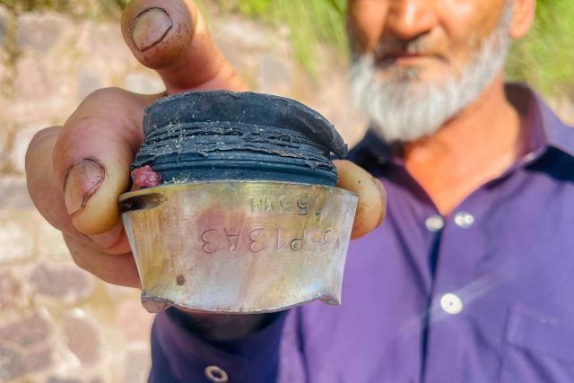 A resident shows a fragment of a mortar shell after the cross-border shelling near the Line of Control (LoC) between Pakistan and India in Chakothi village of Pakistan-administered Kashmir on May 10, 2025. Pakistan on May 10 launched counterattacks against India after three of its air bases were struck overnight, as the conflict between the nuclear-armed neighbours spiralled toward full-blown war. (Photo by Sajjad QAYYUM / AFP)