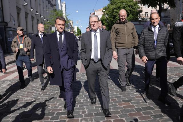 France's President Emmanuel Macron (L) and Britain's Prime Minister Keir Starmer (R) walks in a street of Kyiv on May 10, 2025, ahead of a gathering of European leaders in the Ukranian capital. The leaders of Britain, France, Germany and Poland make an unprecedented joint visit to Kyiv on May 10, 2025 for talks with Ukraine's President Volodymyr and to urge Russia to agree a ceasefire, a joint statement said. (Photo by Stefan Rousseau / POOL / AFP)