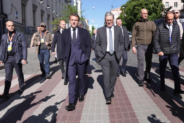 France's President Emmanuel Macron (L) and Britain's Prime Minister Keir Starmer (R) walks in a street of Kyiv on May 10, 2025, ahead of a gathering of European leaders in the Ukranian capital. The leaders of Britain, France, Germany and Poland make an unprecedented joint visit to Kyiv on May 10, 2025 for talks with Ukraine's President Volodymyr and to urge Russia to agree a ceasefire, a joint statement said. (Photo by Stefan Rousseau / POOL / AFP)