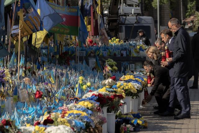 (From L) Ukraine's President Volodymyr Zelensky, Olena Zelenska, Britain's Prime Minister Keir Starmer, France's President Emmanuel Macron and Germany's Chancellor Friedrich Merz pay their respects to the victims of war at the  Memorial for the Fallen at the Independence Square (Maidan) in Kyiv on May 10, 2025, ahead of a gathering of European leaders in the Ukranian capital. The leaders of Britain, France, Germany and Poland make an unprecedented joint visit to Kyiv on May 10, 2025 for talks with Ukraine's President Volodymyr and to urge Russia to agree a ceasefire, a joint statement said. (Photo by Roman PILIPEY / AFP)