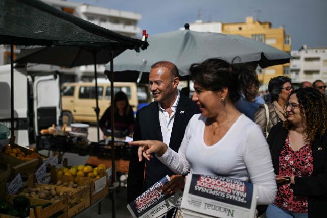 CHEGA far-right party's lawmaker for Algarve, Joao Paulo Graca (L) delivers the party's weekly newspaper to market sellers during a partys electoral campaign action at Quarteira market in Algarve on April 9, 2025. Snap legislative vote take place in Portugal on May 18, the third national election in three years. In Portugal's tourist-friendly south, the far right is gaining ground. Chega (Enough!) came first in the Algarve province in the last poll, with 27.2 percent of the vote. (Photo by PATRICIA DE MELO MOREIRA / AFP)