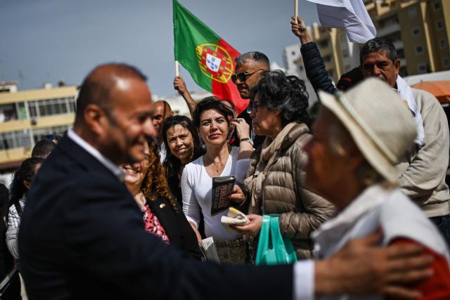 A CHEGA far-right party's member holds a Portugal's flag during a party’s electoral campaign action with CHEGA's lawmaker for Algarve, Joao Paulo Graca at Quarteira market in Algarve on April 9, 2025. Snap legislative vote take place in Portugal on May 18, the third national election in three years. In Portugal's tourist-friendly south, the far right is gaining ground. Chega (Enough!) came first in the Algarve province in the last poll, with 27.2 percent of the vote. (Photo by PATRICIA DE MELO MOREIRA / AFP)