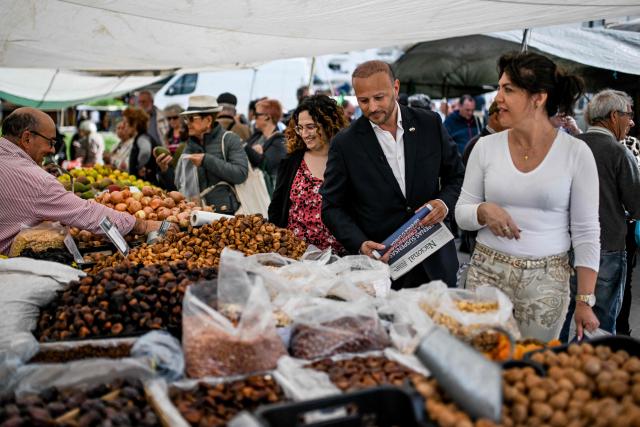CHEGA far-right party's lawmaker for Algarve, Joao Paulo Graca delivers the party's weekly newspaper to market sellers during a partys electoral campaign action at Quarteira market in Algarve on April 9, 2025. Snap legislative vote take place in Portugal on May 18, the third national election in three years. In Portugal's tourist-friendly south, the far right is gaining ground. Chega (Enough!) came first in the Algarve province in the last poll, with 27.2 percent of the vote. (Photo by PATRICIA DE MELO MOREIRA / AFP)