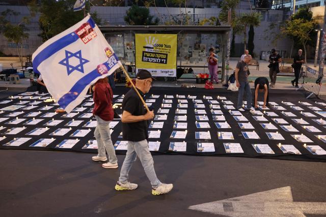 A demonstrator carrying the Israeli flag arrives for an anti-government protest calling for the end of the war and for action to secure the release of Israeli hostages held in the Gaza Strip since the October 7, 2023 attacks by Hamas militants, in front of the Israeli Defence Ministry in Tel Aviv on May 10, 2025. (Photo by Jack GUEZ / AFP)