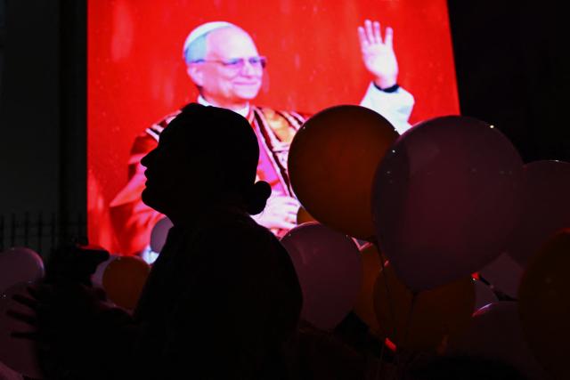A faithful is seen in front of a portrait of newly elected Pope Leo XIV ahead of a mass in honour  of him at the Cathedral of Saint Mary in Chiclayo, Peru on May 10, 2025. US' Robert Francis Prevost, who became a Peruvian national in 2015, was elected pope on May 8, 2025, picking the papal name Leo XIV. The US-born pontiff was bishop of Chiclayo from 2015 to 2023, when he was made a cardinal and moved to Rome. (Photo by ERNESTO BENAVIDES / AFP)