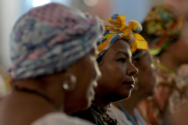 A woman wearing a typical dress looks on during a mass as part of the celebration of Afro-Venezuelan Day in Caucagua, Miranda state, Venezuela on May 10, 2025. Afro-Venezuelan Day is celebrated in Venezuela on May 10, commemorating the heritage and cultural contributions of the Venezuelan Afro-descendant community, as well as their struggle and resistance against slavery. (Photo by Juan BARRETO / AFP)