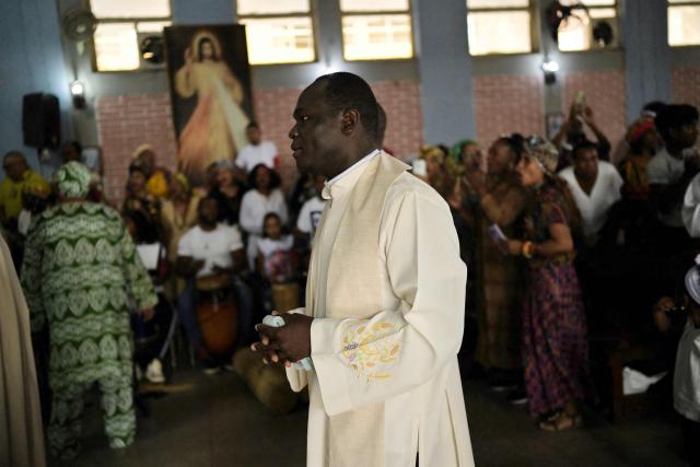A priest walks inside a church during a mass as part of the celebration of Afro-Venezuelan Day in Caucagua, Miranda state, Venezuela on May 10, 2025. Afro-Venezuelan Day is celebrated in Venezuela on May 10, commemorating the heritage and cultural contributions of the Venezuelan Afro-descendant community, as well as their struggle and resistance against slavery. (Photo by Juan BARRETO / AFP)