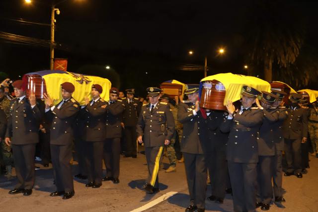 Soldiers carry the coffins with the mortal remains of the 11 soldiers killed on the eve, during their wake at the Eloy Alfaro Military College in Quito on May 10, 2025. Ecuador declared three days of national mourning over the deaths of 11 soldiers who the army said were killed by dissident FARC guerrillas in an ambush in Alto Punino, near the Colombian border. The attack comes amid a spike in violence in both nations linked to the trafficking of cocaine produced in Colombia and exported through Ecuadorean ports to the United States and Europe. (Photo by ARMANDO PRADO / AFP)