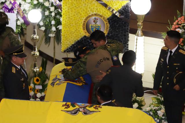 Soldiers reacts in front of one of the coffins with the mortal remains of the 11 soldiers killed on the eve, during their wake at the Eloy Alfaro Military College in Quito on May 10, 2025. Ecuador declared three days of national mourning over the deaths of 11 soldiers who the army said were killed by dissident FARC guerrillas in an ambush in Alto Punino, near the Colombian border. The attack comes amid a spike in violence in both nations linked to the trafficking of cocaine produced in Colombia and exported through Ecuadorean ports to the United States and Europe. (Photo by ARMANDO PRADO / AFP)