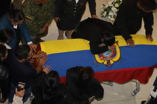 Relatives react in front of one of the coffins with the mortal remains of the 11 soldiers killed on the eve, during their wake at the Eloy Alfaro Military College in Quito on May 10, 2025. Ecuador declared three days of national mourning over the deaths of 11 soldiers who the army said were killed by dissident FARC guerrillas in an ambush in Alto Punino, near the Colombian border. The attack comes amid a spike in violence in both nations linked to the trafficking of cocaine produced in Colombia and exported through Ecuadorean ports to the United States and Europe. (Photo by ARMANDO PRADO / AFP)