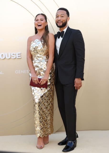 US model Chrissy Teigen (L) and US musician John Legend attend Gold House 4th Gold Gala at the Music Center in Los Angeles, May 10, 2025. Gold Gala, the annual gathering of top Asian Pacific and multicultural leaders, celebrates the 100 most impactful Asian Pacific changemakers in culture and society over the past year. (Photo by Michael Tran / AFP)
